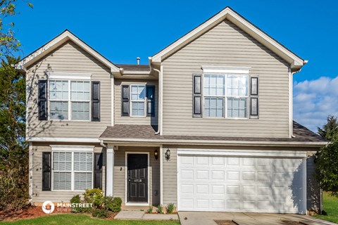 a beige house with a white garage door